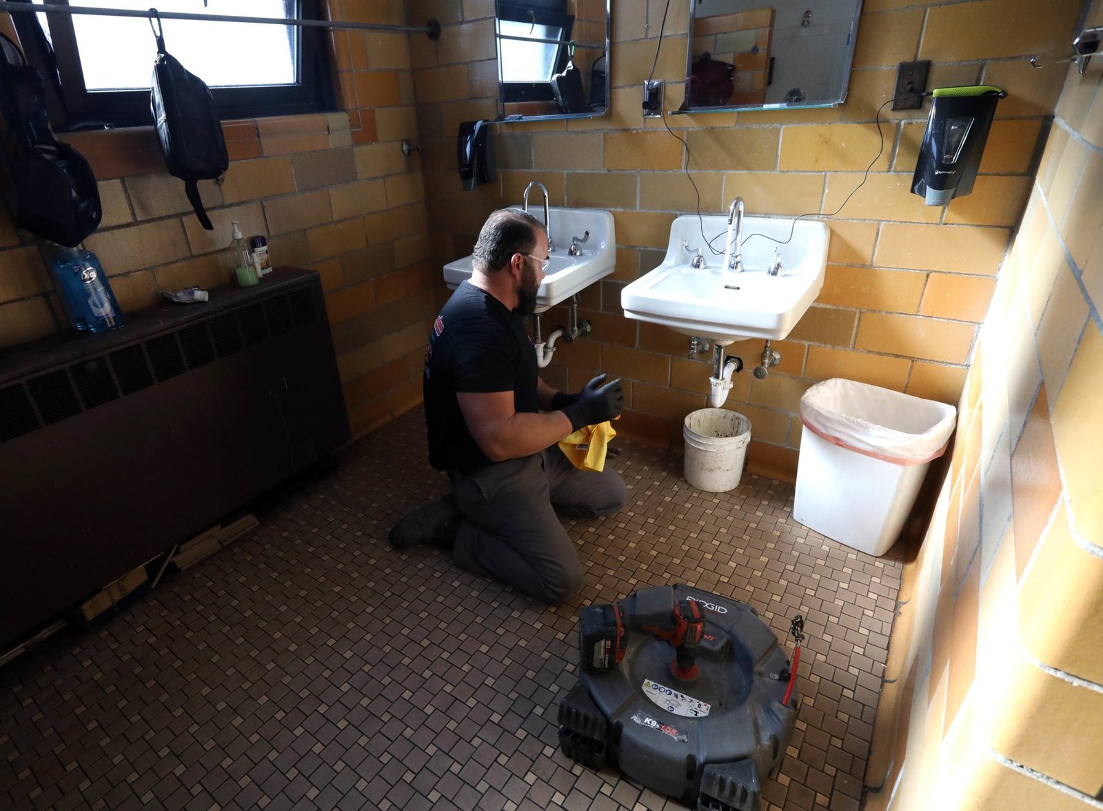 Drain-cleaning machine set up in a commercial restroom