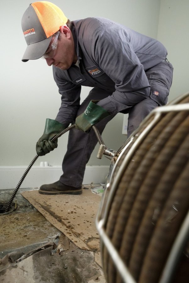 Technician feeding a drain cable into an access point